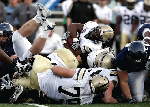 Kyler Murray Signs with the Minnesota Vikings Intense action scene of football players tackling during a game, showcasing teamwork and sportsmanship.